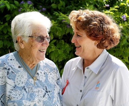 IRT carer smiling with eldery woman in retirement village